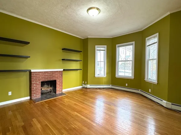 a view of an empty room with a fireplace and a window