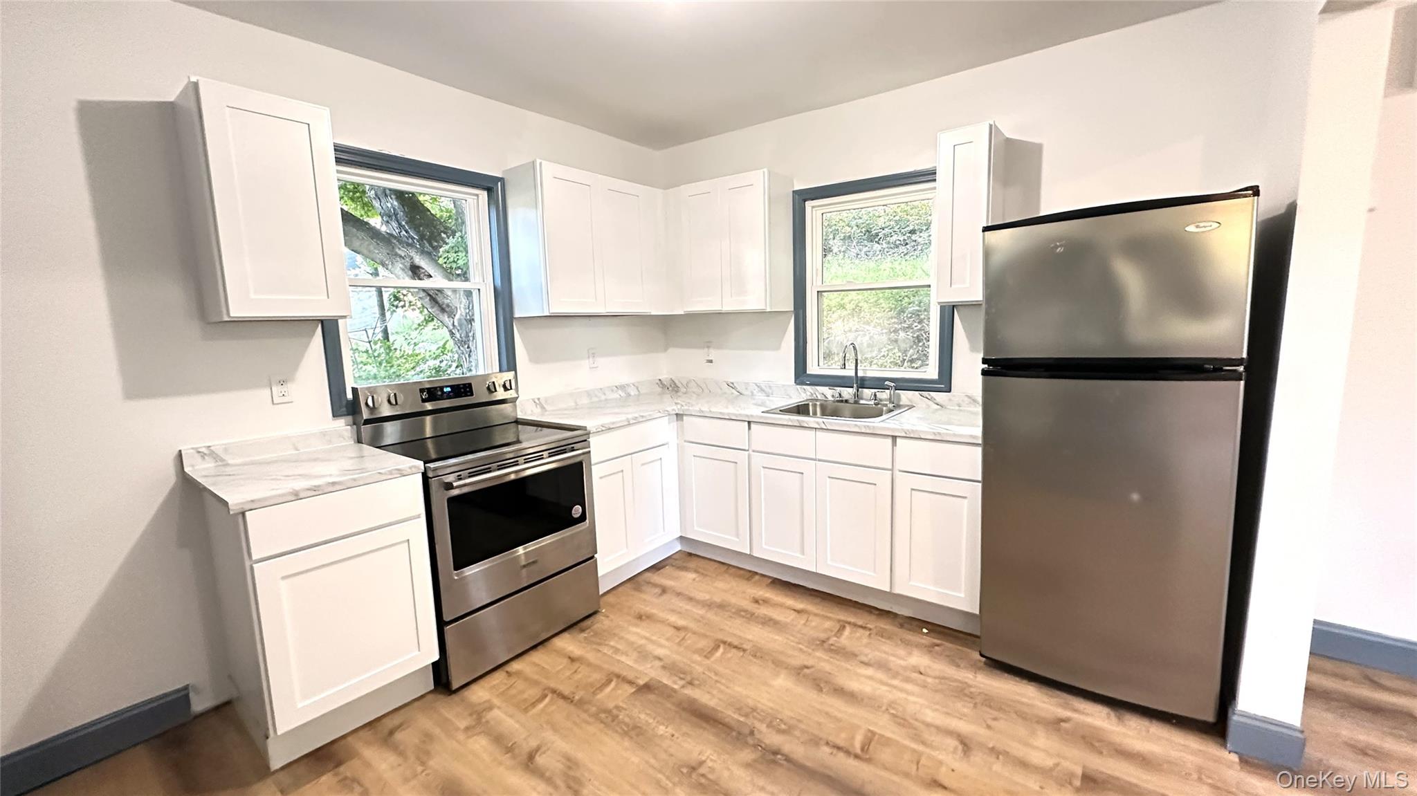 154 Smith Street Poughkeepsie, NY 12601 - Photo 2 of 13 a kitchen with a refrigerator white stove a sink and a window