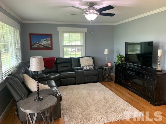 8609 Cassam Road Bahama, NC 27503 - Photo 11 of 23 a living room with furniture a large window and a flat screen tv