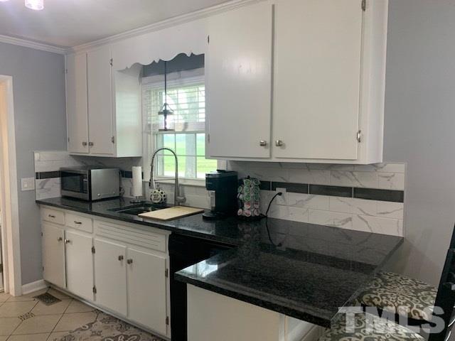 8609 Cassam Road Bahama, NC 27503 - Photo 23 of 23 a kitchen with granite countertop a sink a stove and cabinets