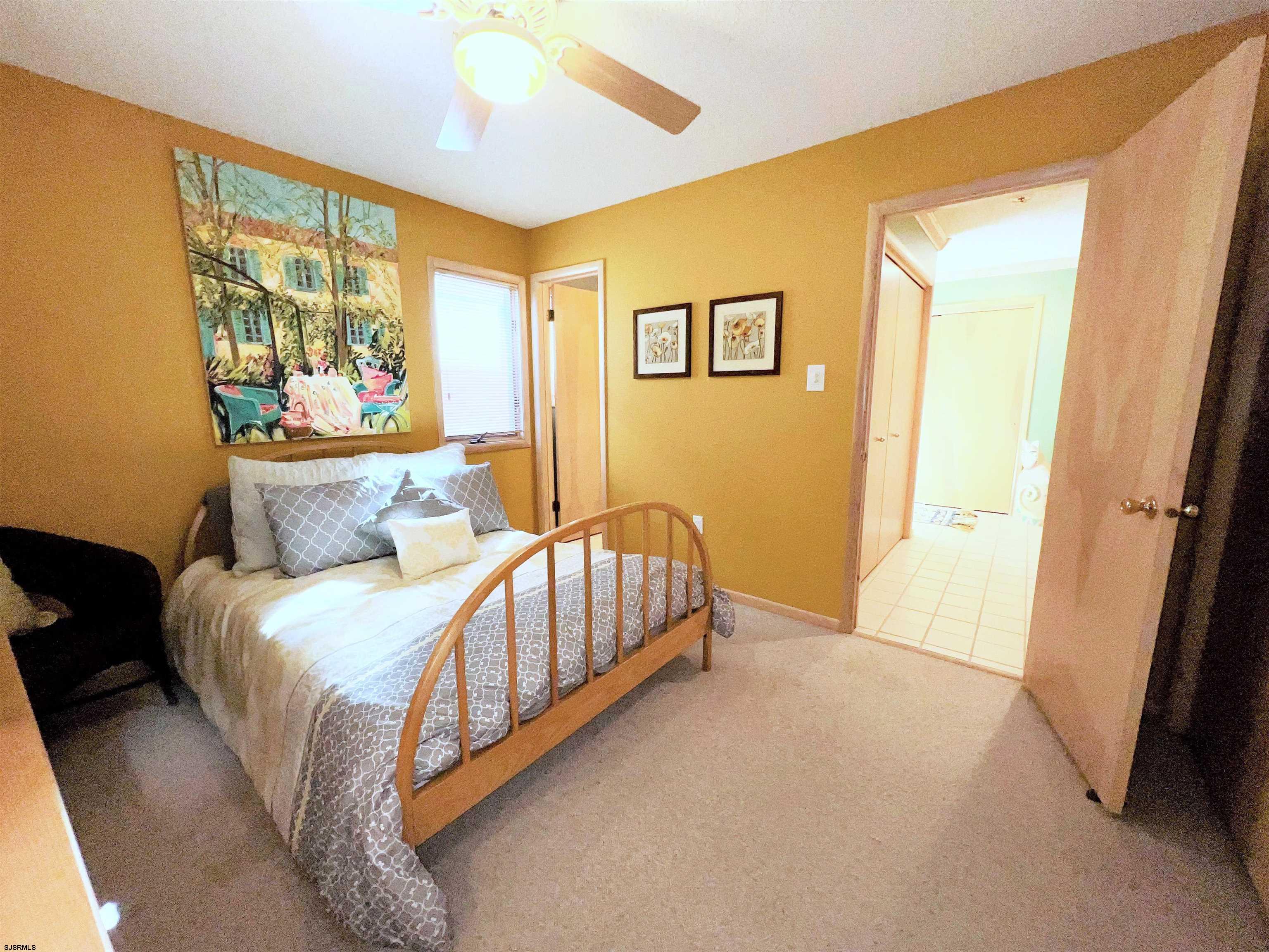 211 3rd Street North, Unit B Brigantine, NJ 08203 - Photo 11 of 52 a bed room with a bed and a painting on the wall