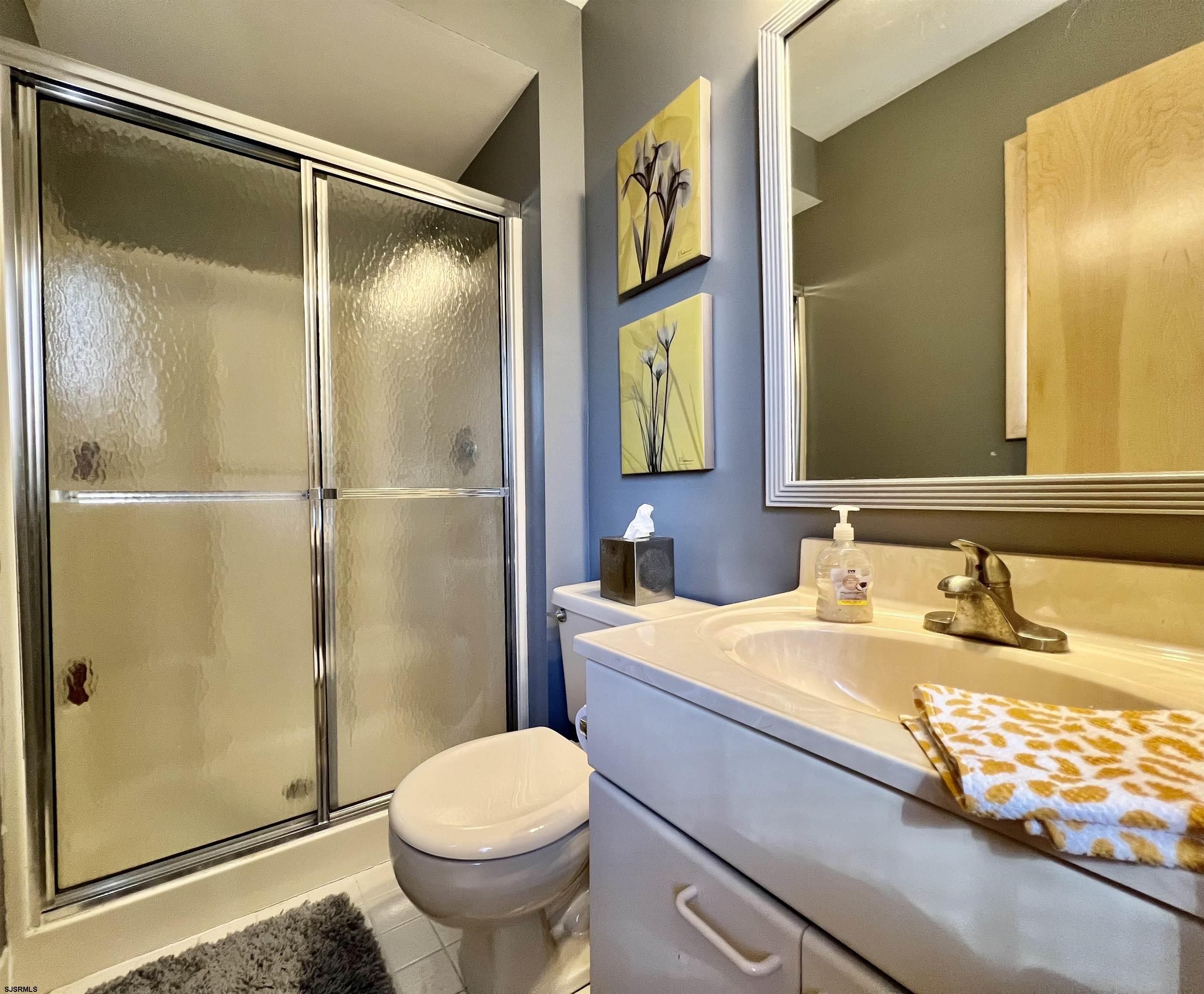211 3rd Street North, Unit B Brigantine, NJ 08203 - Photo 13 of 52 a bathroom with a sink and a mirror