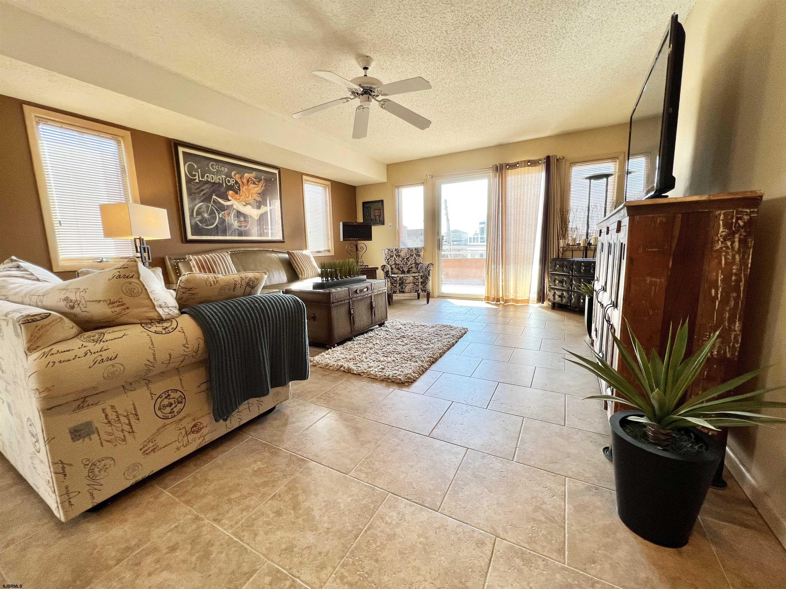 211 3rd Street North, Unit B Brigantine, NJ 08203 - Photo 16 of 52 a living room with furniture a fireplace and a flat screen tv