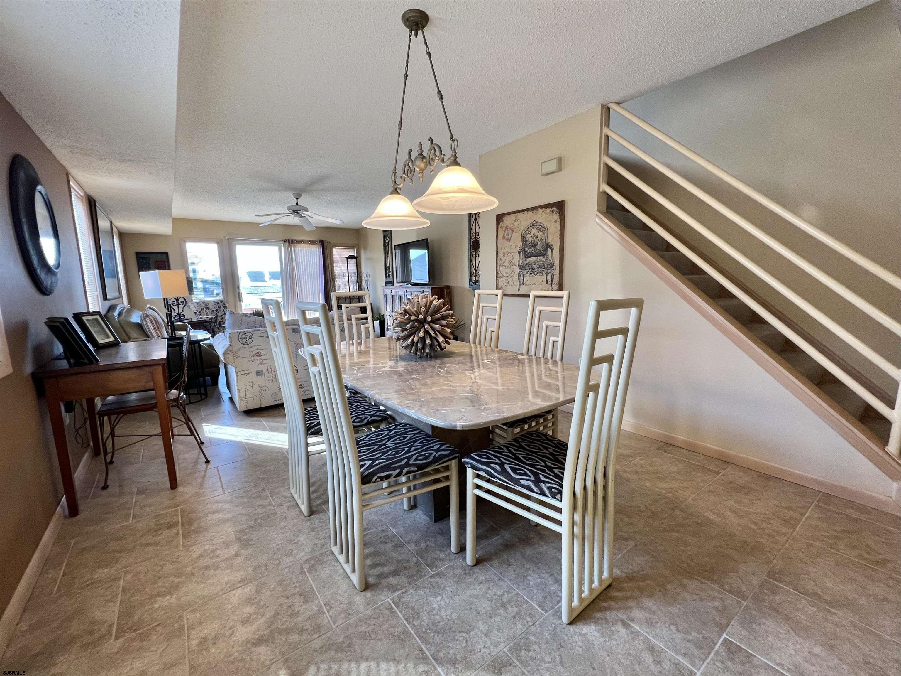 211 3rd Street North, Unit B Brigantine, NJ 08203 - Photo 19 of 52 a dining room with furniture and a chandelier