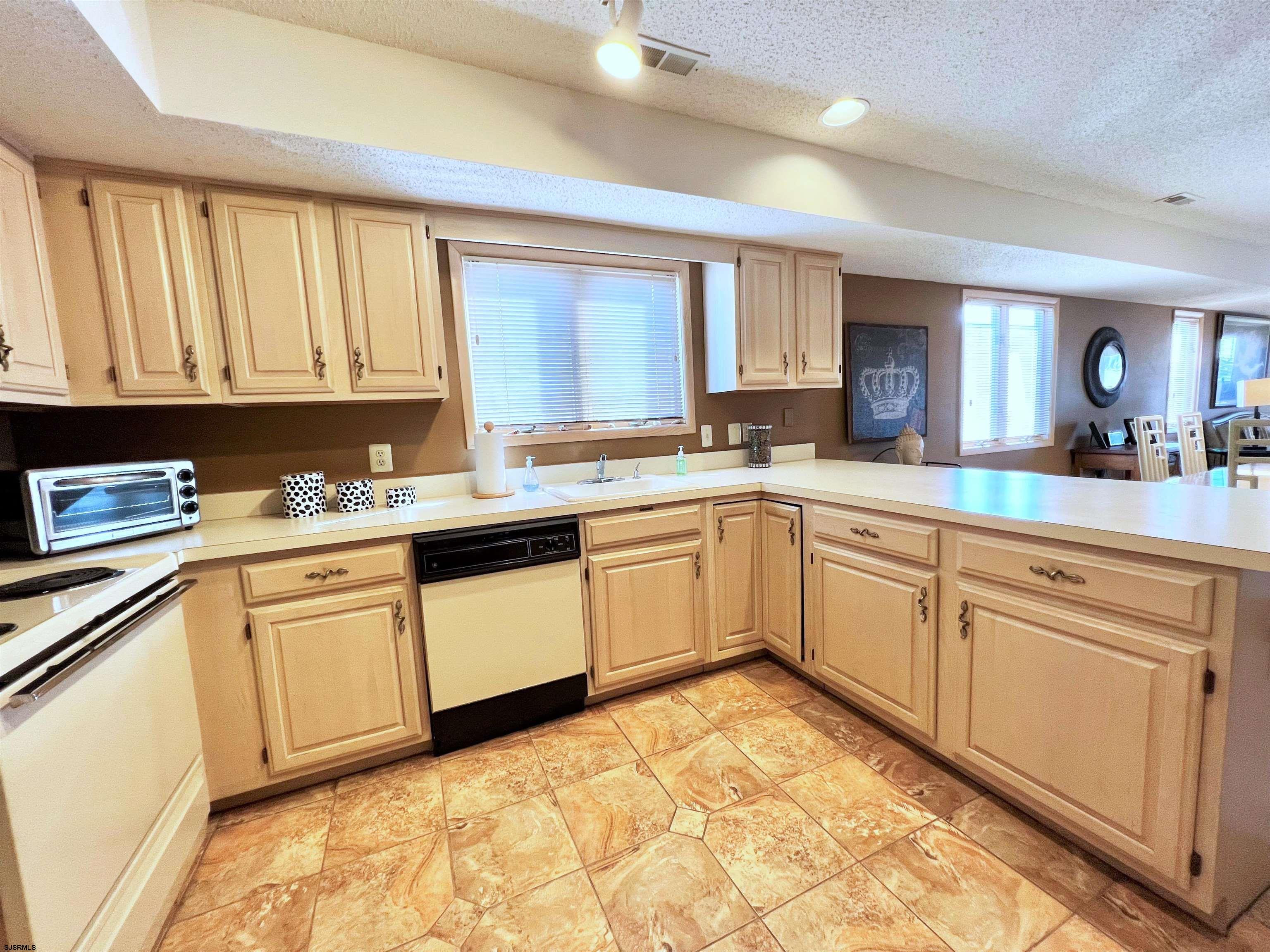 211 3rd Street North, Unit B Brigantine, NJ 08203 - Photo 21 of 52 a kitchen with granite countertop a sink window and cabinets