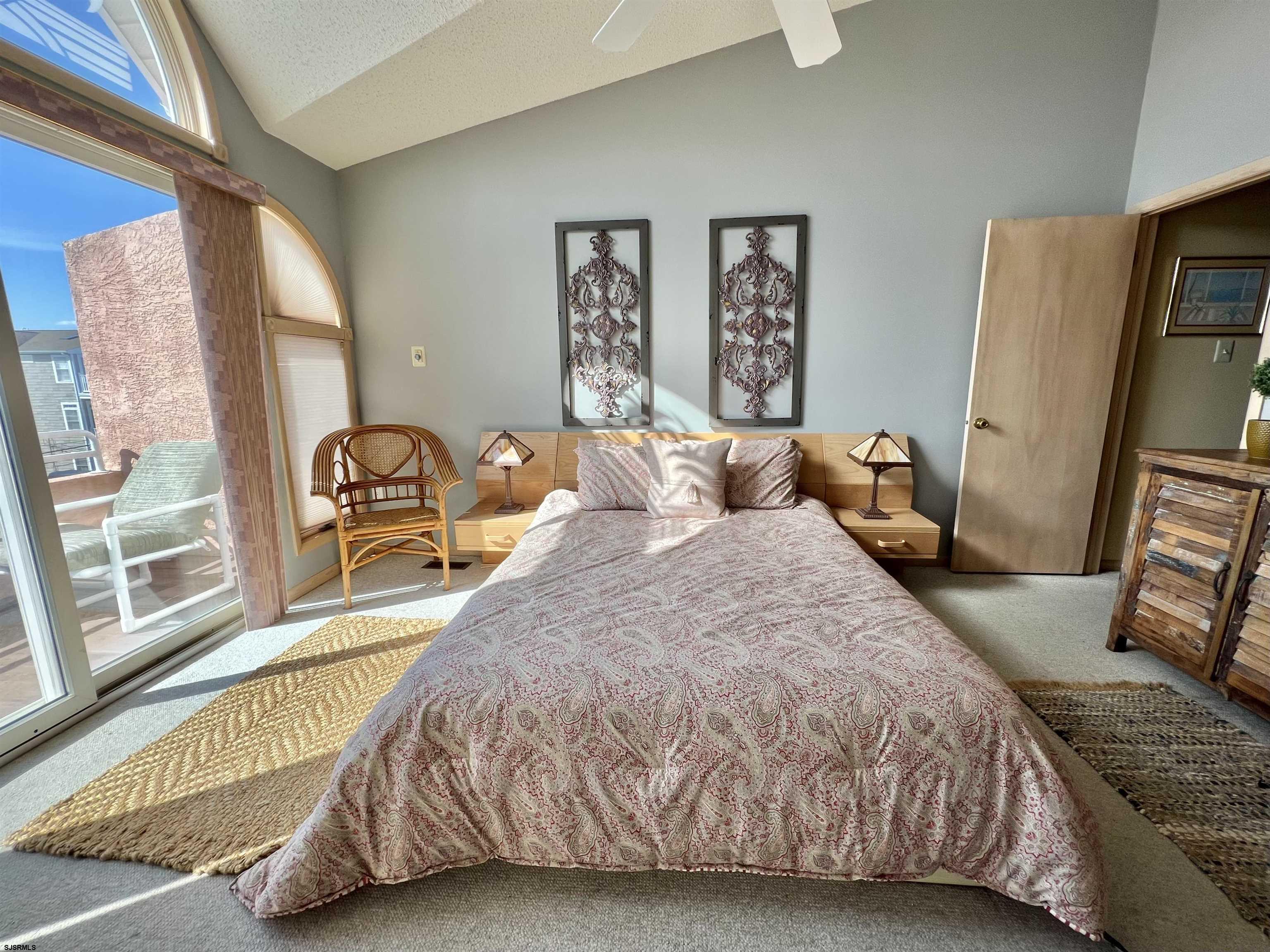 211 3rd Street North, Unit B Brigantine, NJ 08203 - Photo 27 of 52 a bedroom with a bed a flat screen tv and next to a window