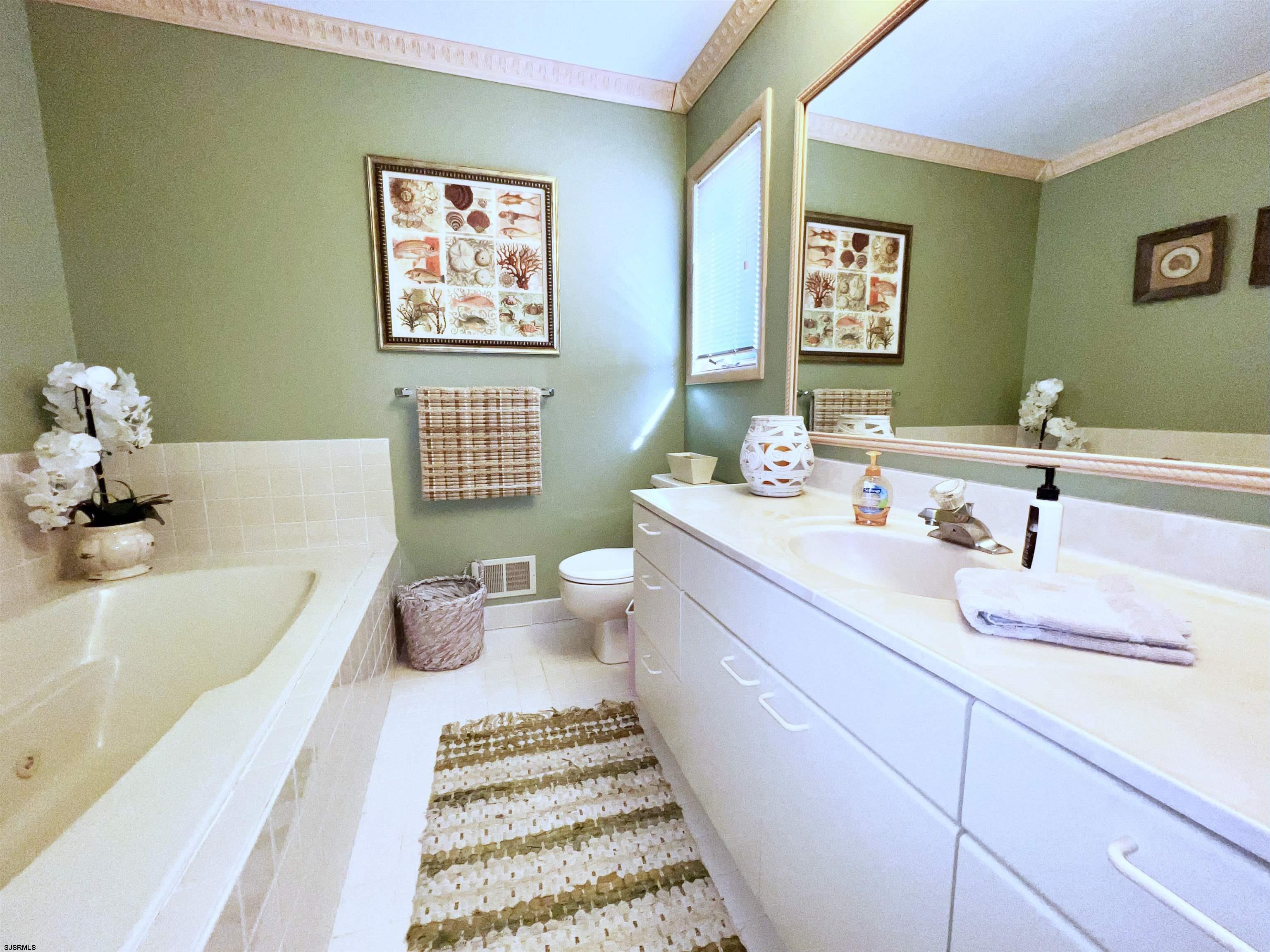 211 3rd Street North, Unit B Brigantine, NJ 08203 - Photo 33 of 52 a bathroom with a bathtub sink and mirror