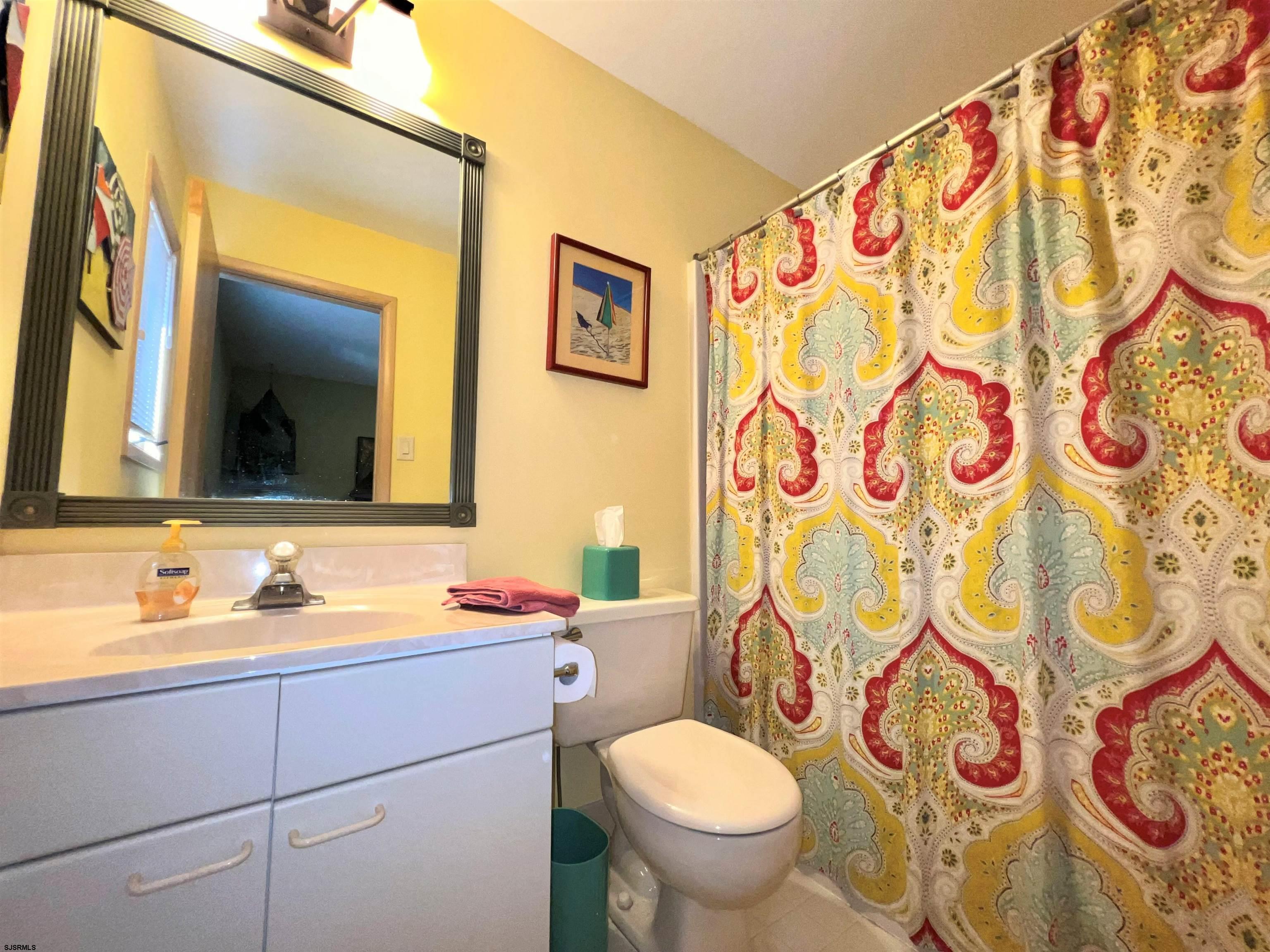 211 3rd Street North, Unit B Brigantine, NJ 08203 - Photo 40 of 52 a bathroom with a sink and mirror with toilet