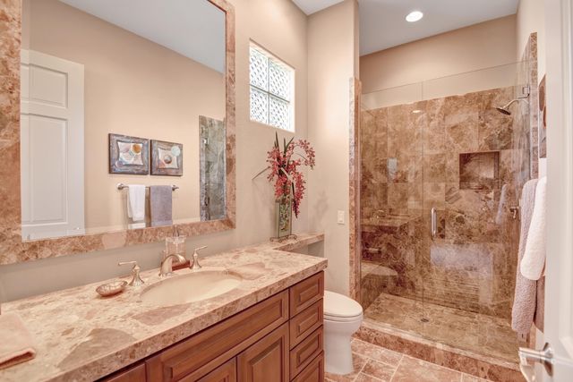 a bathroom with a granite countertop sink mirror and shower