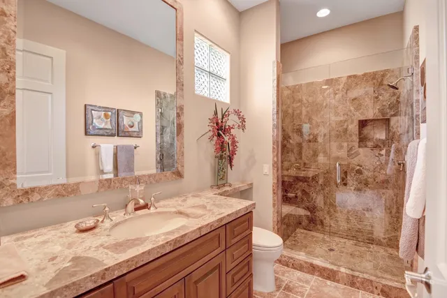 a bathroom with a granite countertop sink mirror and shower