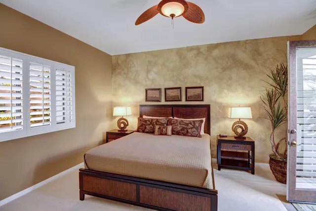 a bedroom with a bed and a lamp next to a window