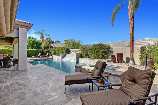 a view of a patio with table and chairs potted plants and palm tree