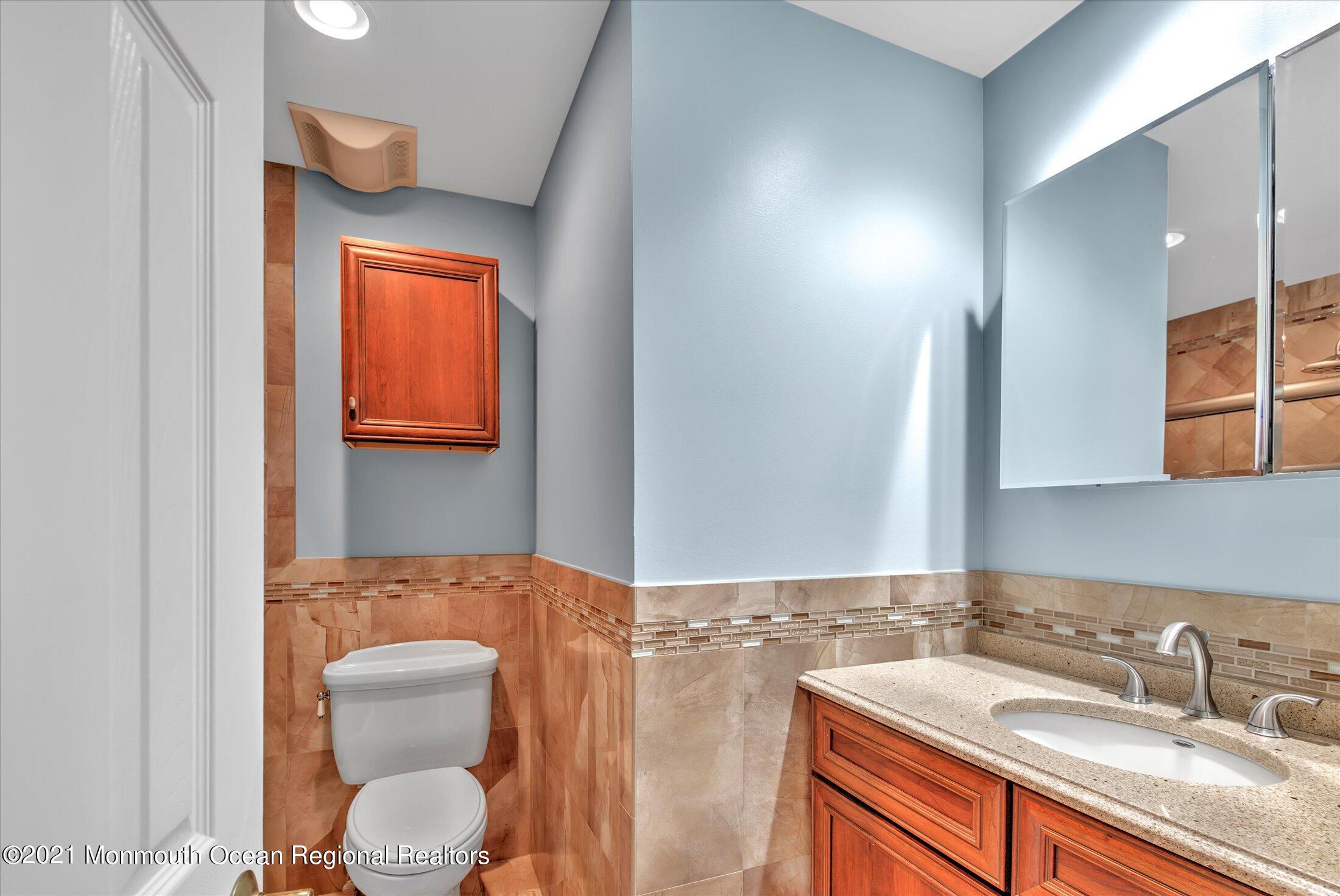 74 Sargent Road Freehold, NJ 07728 - Photo 17 of 23 a bathroom with a toilet a sink a mirror and vanity