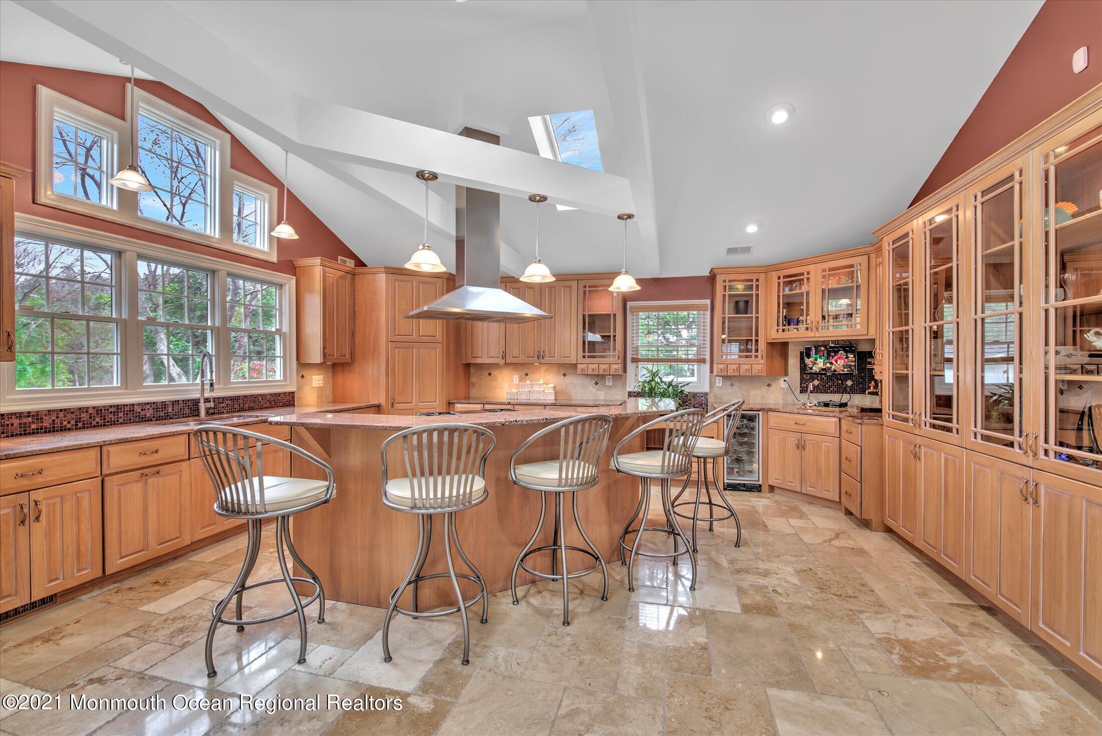 74 Sargent Road Freehold, NJ 07728 - Photo 7 of 23 a kitchen with stainless steel appliances kitchen island granite countertop a table chairs and a wooden cabinets