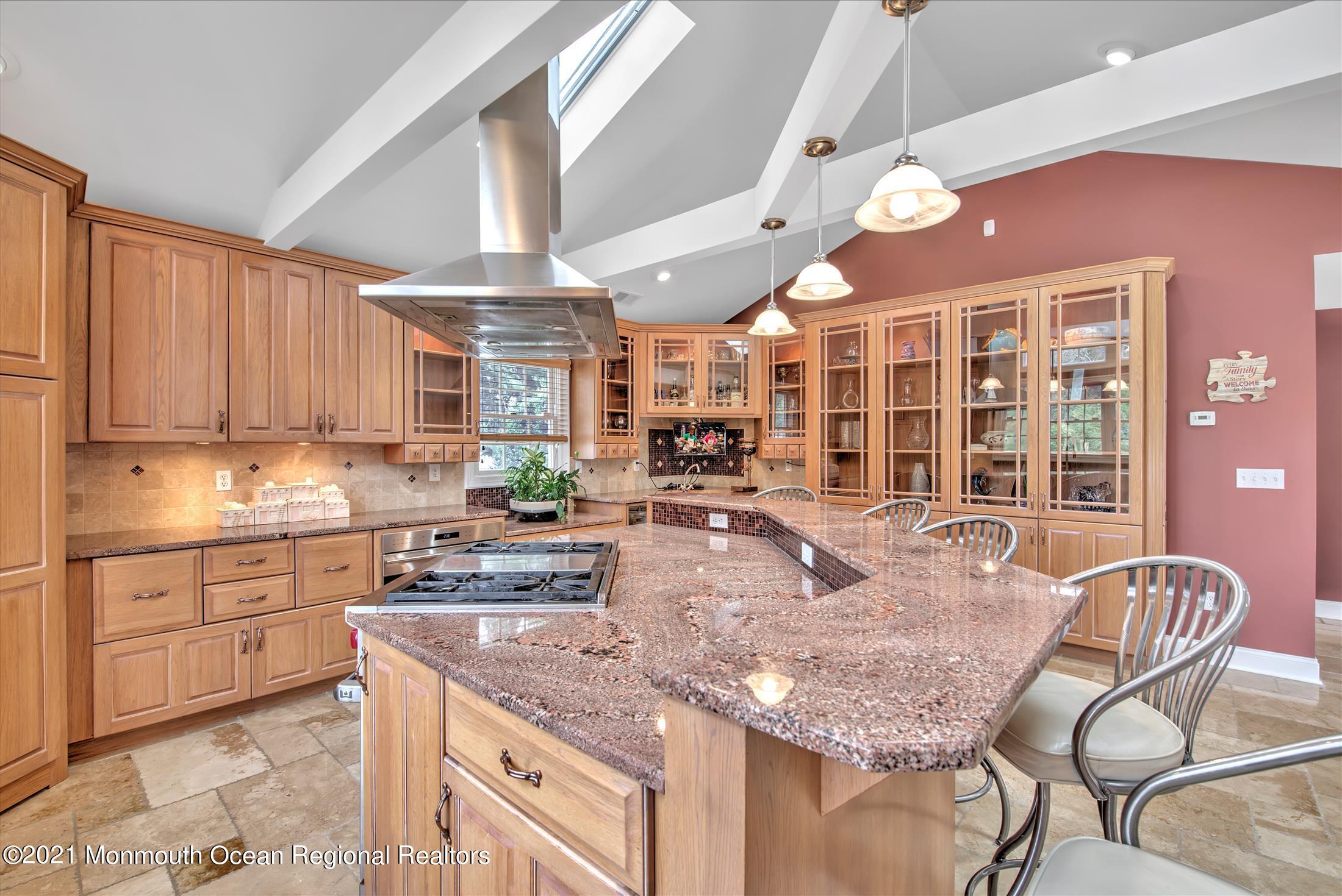 74 Sargent Road Freehold, NJ 07728 - Photo 9 of 23 a kitchen with stainless steel appliances granite countertop a stove a sink dishwasher and cabinets with wooden floor