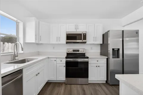 a kitchen with a sink stove and refrigerator