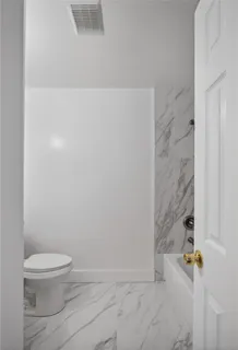 a spacious bathroom with a toilet sink and mirror