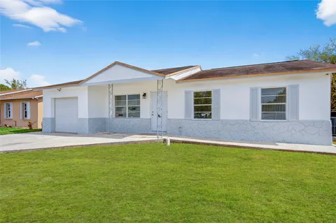 a backyard of a house with lots of green space and fountain