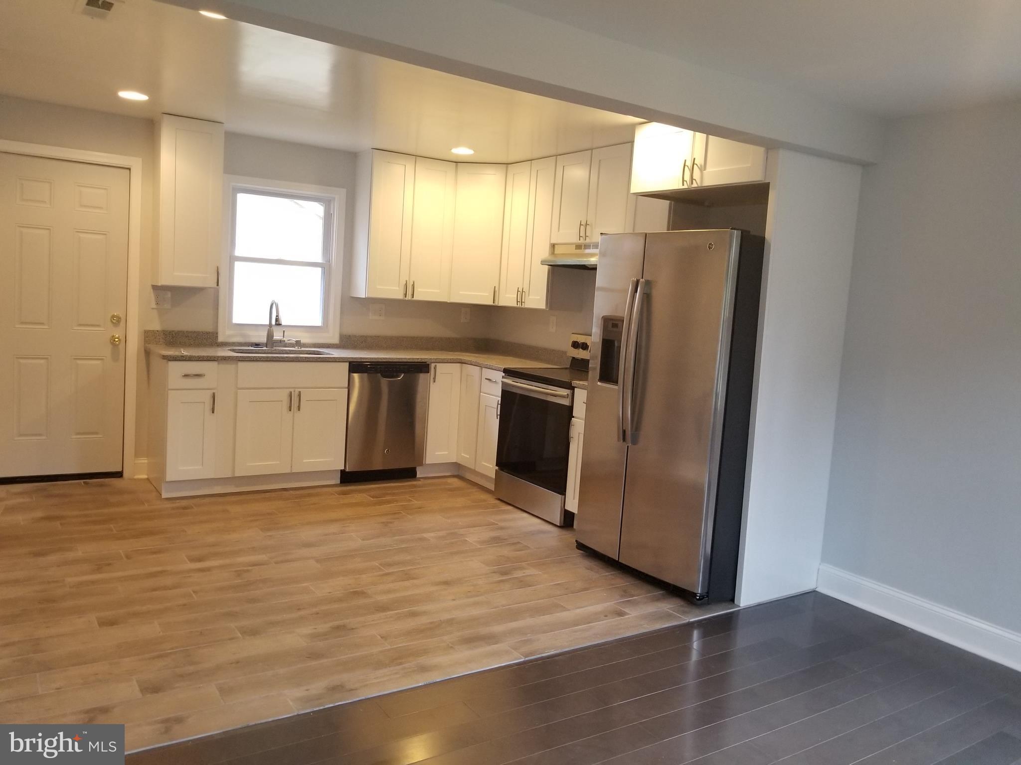 6828 Campfield Road Baltimore, MD 21207 - Photo 3 of 26 a kitchen with stainless steel appliances granite countertop a refrigerator a sink a stove and oven