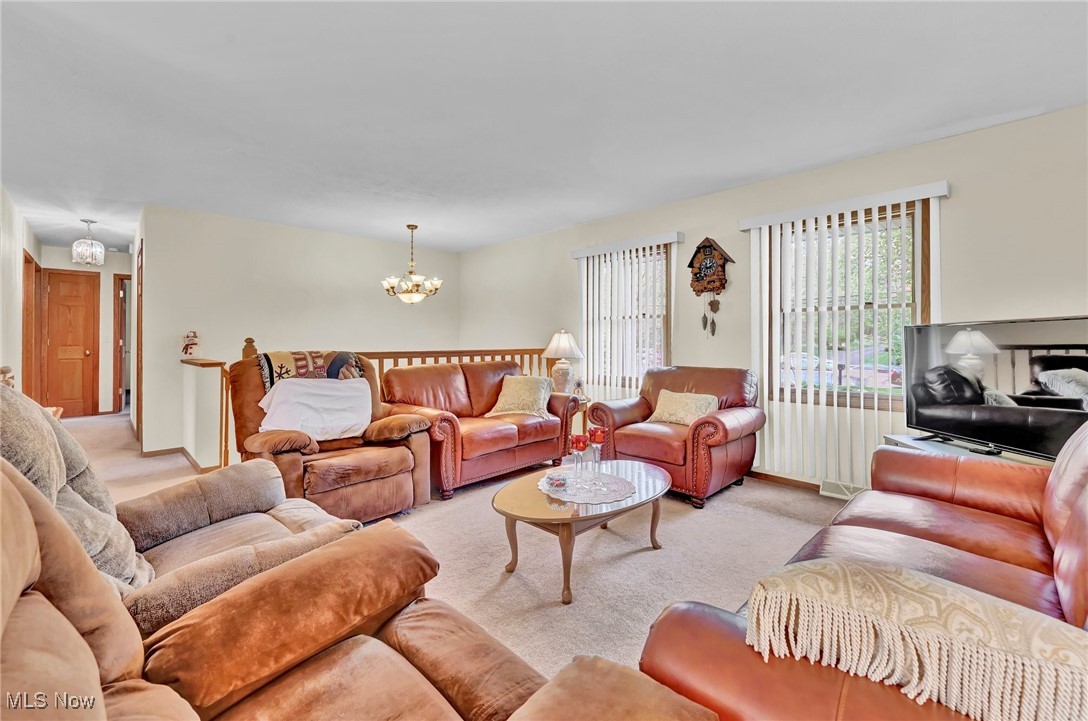 7676 Brecksville Road Independence, OH 44131 - Photo 9 of 32 Living room with an inviting chandelier and light carpet