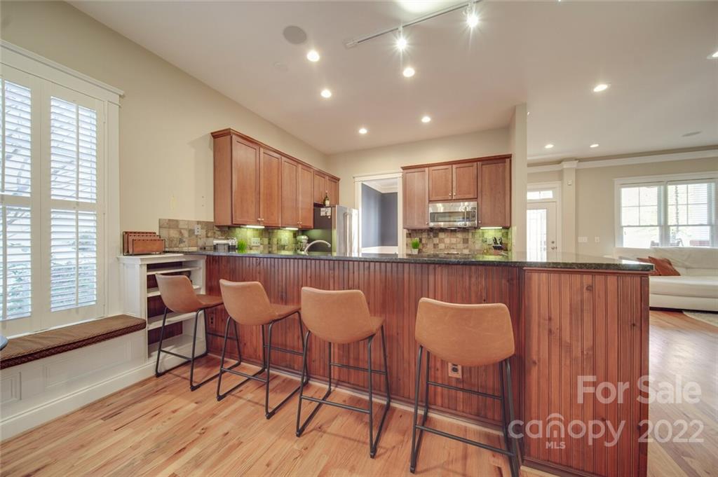 220 Mills Lane Fort Mill, SC 29708 - Photo 11 of 42 a kitchen with stainless steel appliances granite countertop a stove top oven a sink dishwasher and a dining table with wooden floor