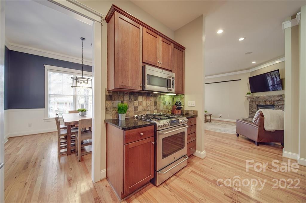 220 Mills Lane Fort Mill, SC 29708 - Photo 14 of 42 a kitchen with stainless steel appliances granite countertop a stove a sink dishwasher and a refrigerator with wooden floor