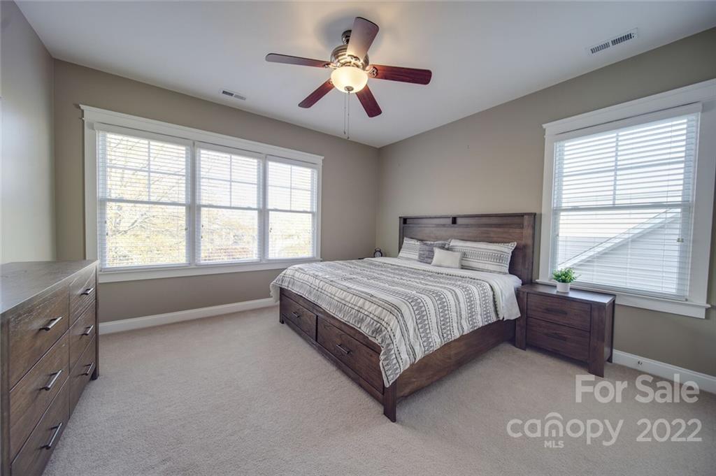 220 Mills Lane Fort Mill, SC 29708 - Photo 23 of 42 a spacious bedroom with a large bed and a chandelier fan