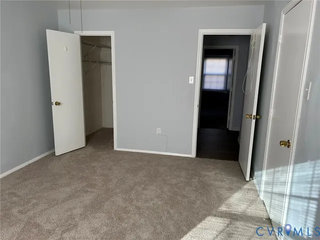 an empty room with closet and mirror
