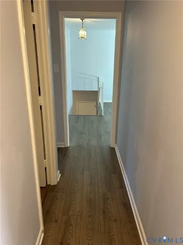 a view of a hallway with wooden floor and staircase