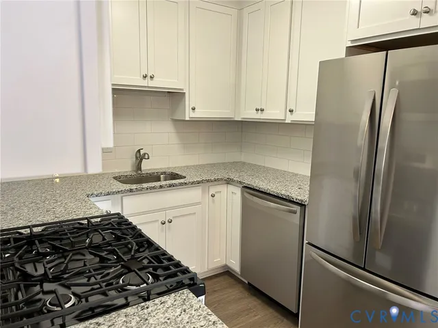 a kitchen with a refrigerator stove and white cabinets