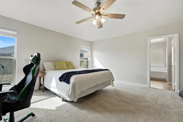 a bedroom with a bed lamp and a chandelier