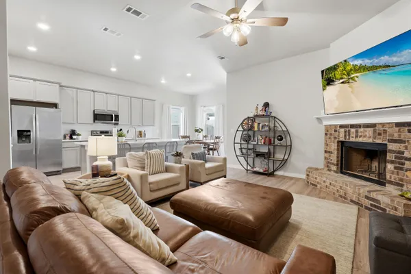 a living room with furniture a fireplace and kitchen view