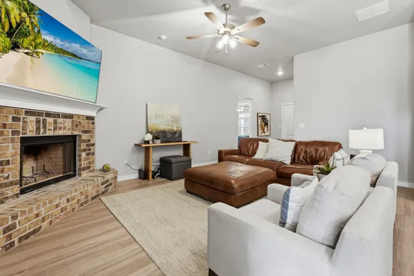a living room with furniture a fireplace and a chandelier