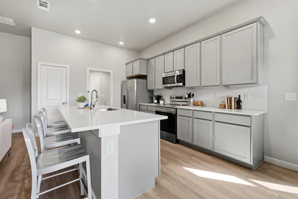 a kitchen with white cabinets and stainless steel appliances