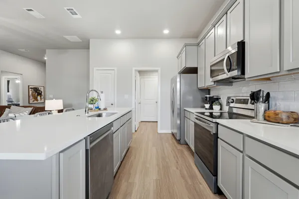 a kitchen with stainless steel appliances granite countertop a sink stove and refrigerator