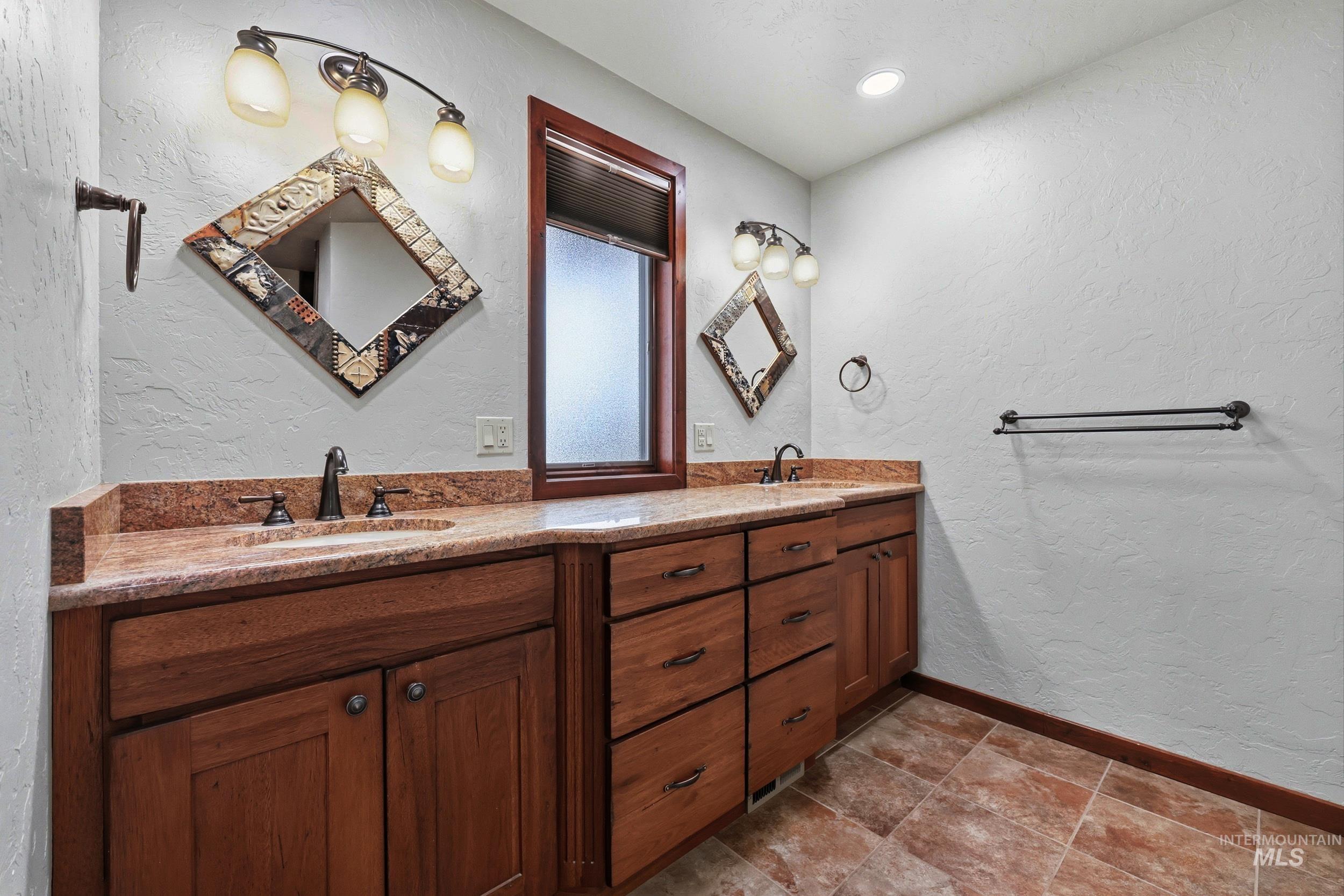 339 Airport Road Weiser, ID 83672 - Photo 25 of 49 Dual sink vanity featuring wood cabinetry and a polished stone countertop