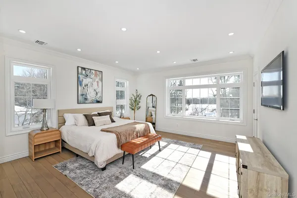 a bedroom with a large bed and wooden floor