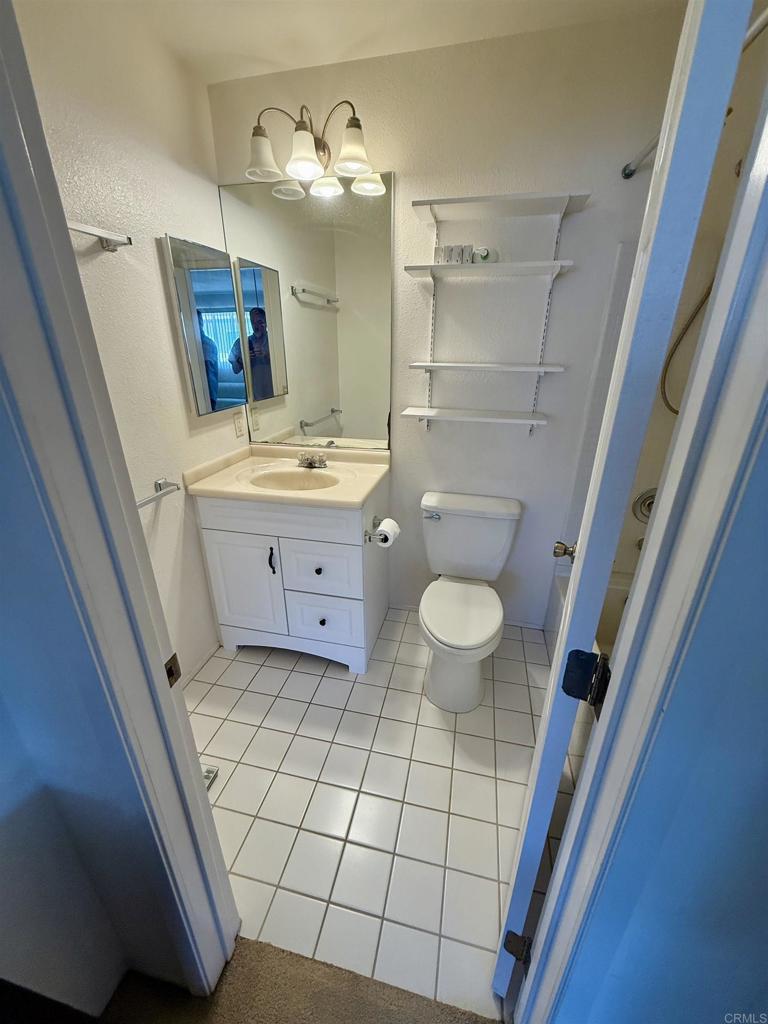 9575 Easter Way, Unit 5 San Diego, CA 92121 - Photo 7 of 19 a bathroom with a sink a toilet a mirror a vanity and shower