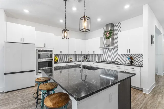 a kitchen with kitchen island a sink stove and refrigerator
