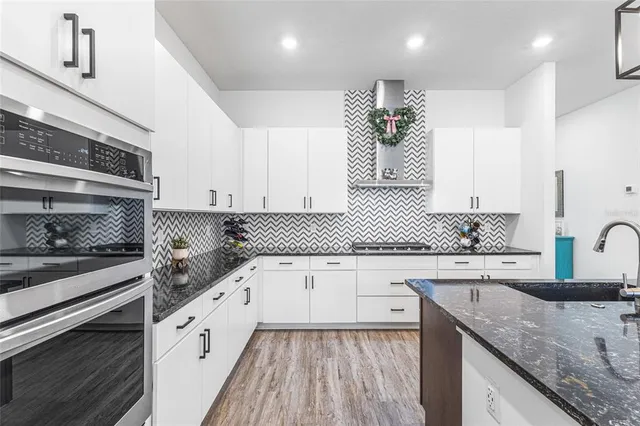 a kitchen with granite countertop a sink stove and cabinets