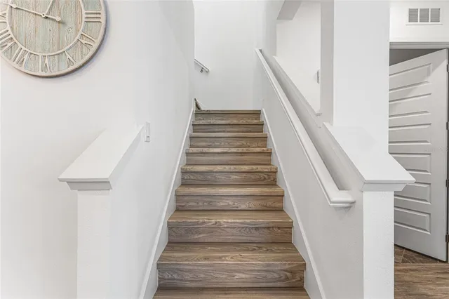 a view of staircase with white walls and railing