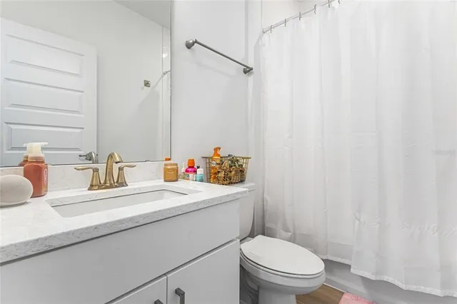 a bathroom with a sink a toilet and shower curtain