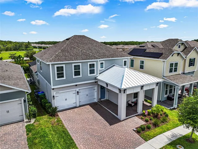a view of house with a yard and potted plants