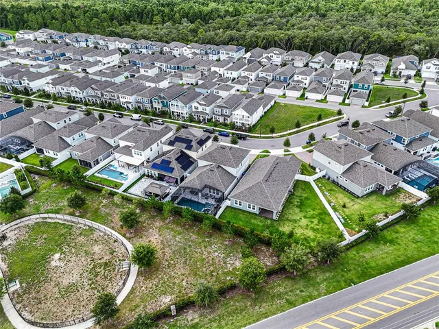 an aerial view of residential houses with outdoor space and swimming pool