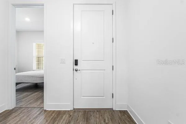 a view of a bedroom from hallway with wooden floor