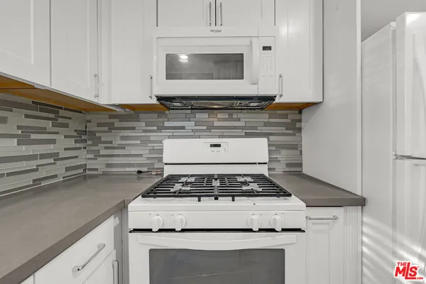 a white stove top oven sitting inside of a kitchen