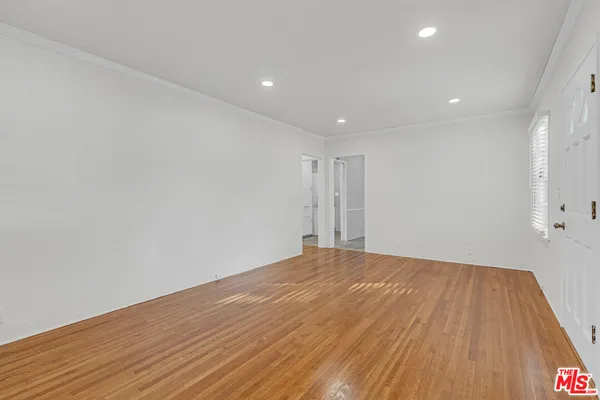 a view of empty room with wooden floor