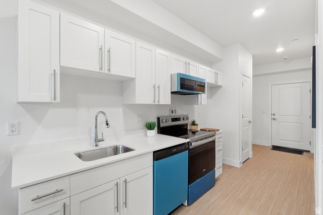 2085 North Main Street, Unit 107 Sunset, UT 84015 - Photo 5 of 21 Kitchen with white cabinets, electric range, dishwashing machine, light wood finished floors, and recessed lighting