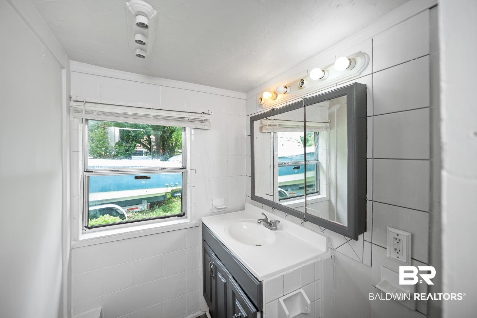 19575 Keller Road Foley, AL 36535 - Photo 14 of 17 Bathroom with vanity, tile walls, and ornamental molding