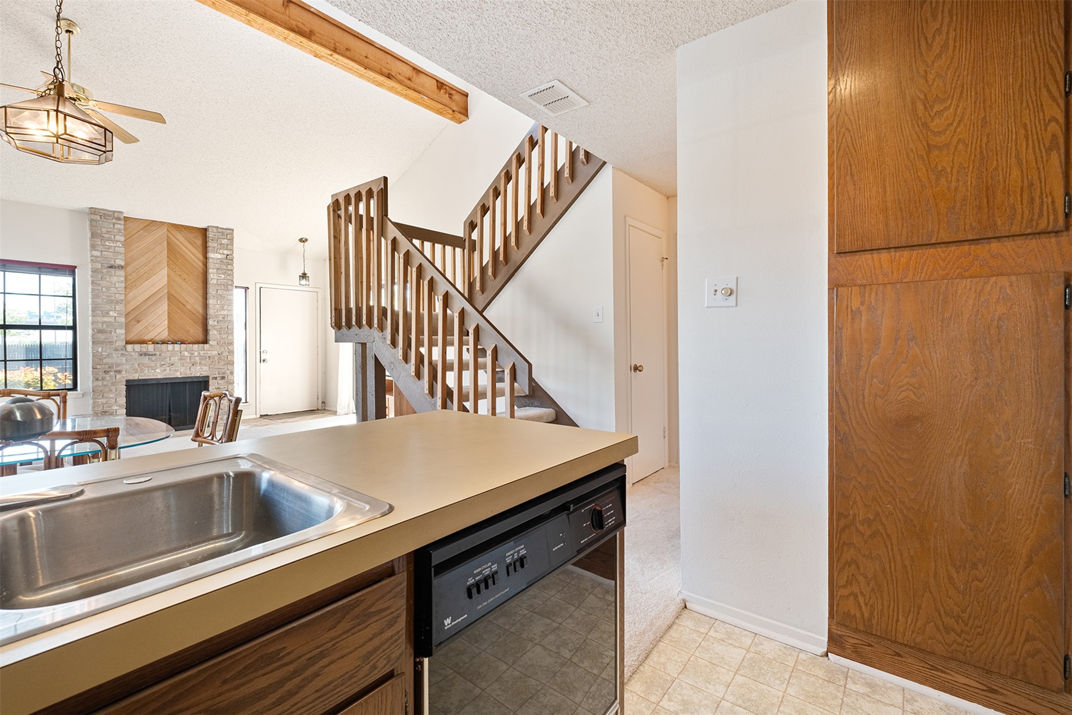 1748 Ohlen Road, Unit 16 Austin, TX 78757 - Photo 38 of 38 Kitchen featuring a textured ceiling, dishwasher, a fireplace, light countertops, and open floor plan